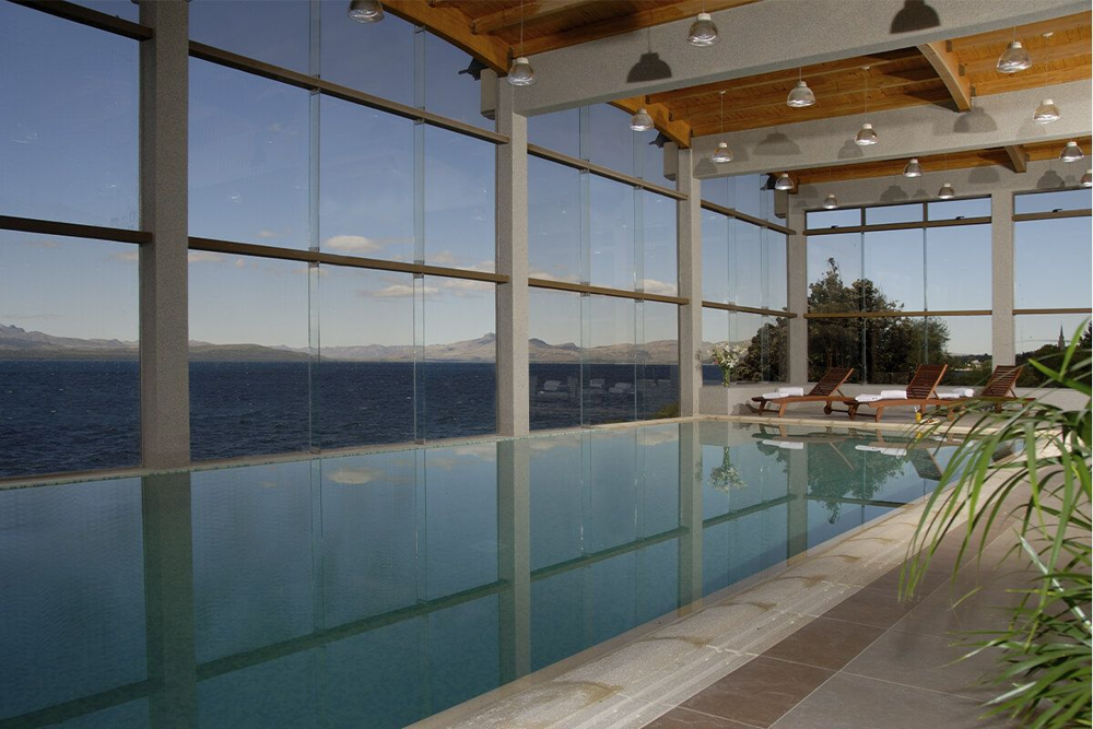 Indoor pool at Alma del Lago, with picture windows that invite the Nahuel Huapi landscape to be part of the spa.